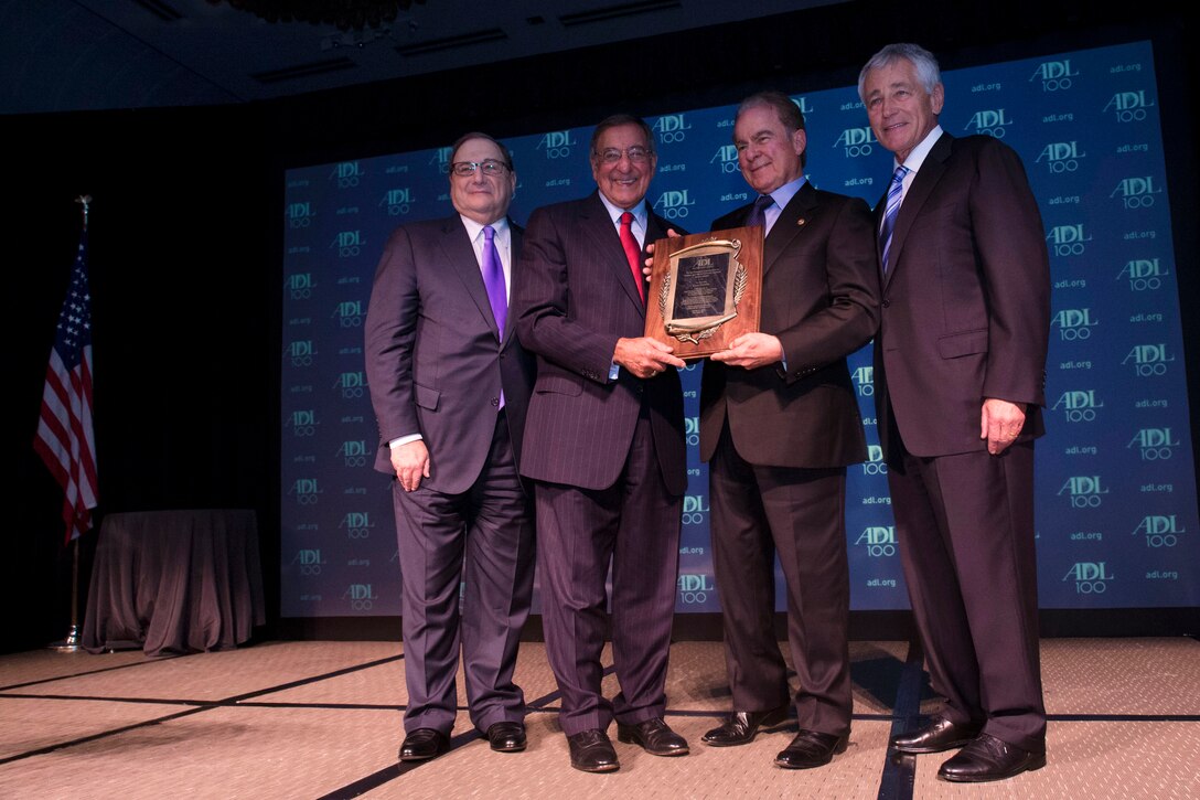Defense Secretary Chuck Hagel, right, helps Anti-Defamation League National Director Abraham H. Foxman, left, present former Defense Secretary Leon E. Panetta, center left, with the William and Naomi Gorowitz Institute Service Award at the centennial dinner for the Anti-Defamation League in New York, Oct. 31, 2013.