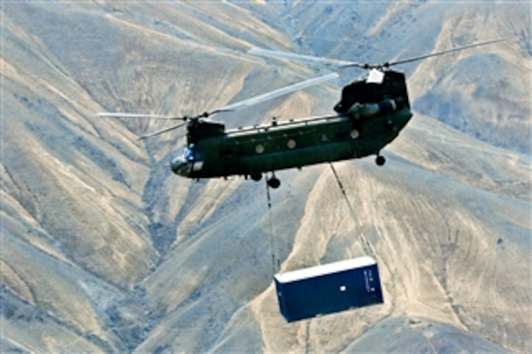 A U.S. Army CH-47 Chinook helicopter carries a sling-loaded shipping container during retrograde operations and base closures in the Wardak province of Afghanistan on Oct. 26, 2013.  The Chinook is assigned to the 10th Combat Aviation Brigade.  