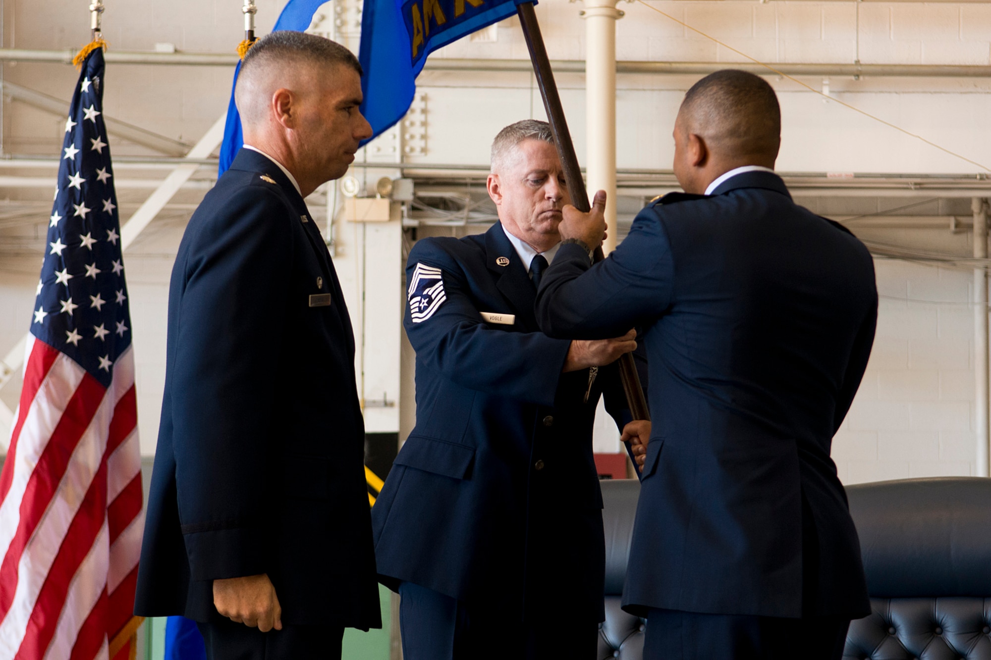 U.S. Air Force Maj. Steven Cabrera hands the 307th Aircraft Maintenance Squadron (AMXS) guidon to Chief Master Sgt. Steven Vogle after assuming command of the squadron on Nov. 2, 2013, Barksdale Air Force Base, La. Cabrera is the former Operations Officer assigned to the 926th AMXS at Nellis Air Force Base, Nev. (U.S. Air Force photo by Master Sgt. Greg Steele/Released)