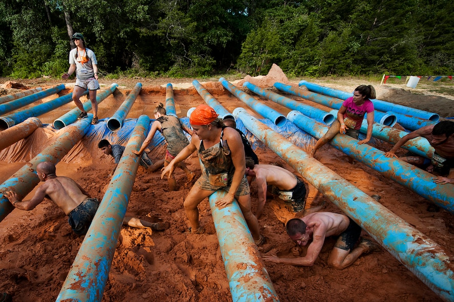 Runners crawl over and under a pipe obstacle during the Emerald Coast MudRun for Orphans in Niceville Fla., May 18, 2013.  Active-duty and reserve service members from Duke and Hurlburt Field, Eglin Air Force Base and more came out to get dirty in either the five-mile warrior challenge or the other 5K races throughout the day.  More than 1,000 runners attended the event.  (U.S. Air Force photo/Tech. Sgt. Sam King)