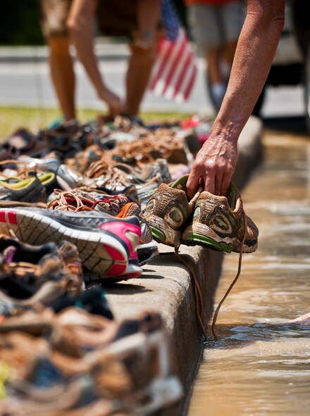 A runner drops off her shoes as a donation after she completed the Emerald Coast MudRun for Orphans in Niceville Fla., May 18, 2013.  Active-duty and reserve service members from Duke and Hurlburt Field, Eglin Air Force Base and more came out to get dirty in either the five-mile warrior challenge or the other 5K races throughout the day.  More than 1,000 runners attended the event.  (U.S. Air Force photo/Tech. Sgt. Sam King)