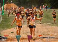 Female military members lead a large group of runners toward the next mud obstacle the Emerald Coast MudRun for Orphans in Niceville Fla., May 18, 2013.  Active-duty and reserve service members from Duke and Hurlburt Field, Eglin Air Force Base and more came out to get dirty in either the five-mile warrior challenge or the other 5K races throughout the day.  More than 1,000 runners attended the event.  (U.S. Air Force photo/Tech. Sgt. Sam King)