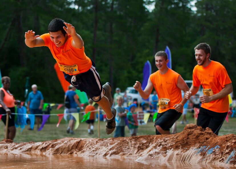 A runner takes a dive into the first muddy obstacle at the Emerald Coast MudRun for Orphans in Niceville Fla., May 18, 2013.  Active-duty and reserve service members from Duke and Hurlburt Field, Eglin Air Force Base and more came out to get dirty in either the five-mile warrior challenge or the other 5K races throughout the day.  More than 1,000 runners attended the event.  (U.S. Air Force photo/Tech. Sgt. Sam King)