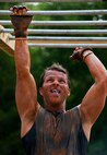 A military member climbs across a set of monkey bars at the Emerald Coast MudRun for Orphans in Niceville Fla., May 18, 2013.  Active-duty and reserve service members from Duke and Hurlburt Field, Eglin Air Force Base and more came out to get dirty in either the five-mile warrior challenge or the other 5K races throughout the day.  More than 1,000 runners attended the event.  (U.S. Air Force photo/Tech. Sgt. Sam King)