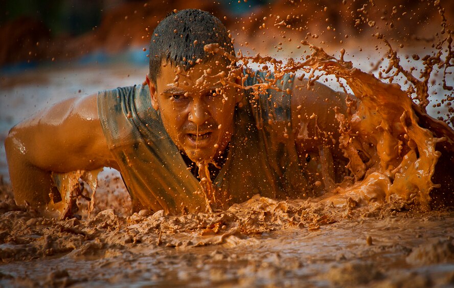 A runner blasts through the first muddy obstacle at the Emerald Coast MudRun for Orphans in Niceville Fla., May 18, 2013.  Active-duty and reserve service members from Duke and Hurlburt Field, Eglin Air Force Base and more came out to get dirty in either the five-mile warrior challenge or the other 5K races throughout the day.  More than 1,000 runners attended the event.  (U.S. Air Force photo/Tech. Sgt. Sam King)
