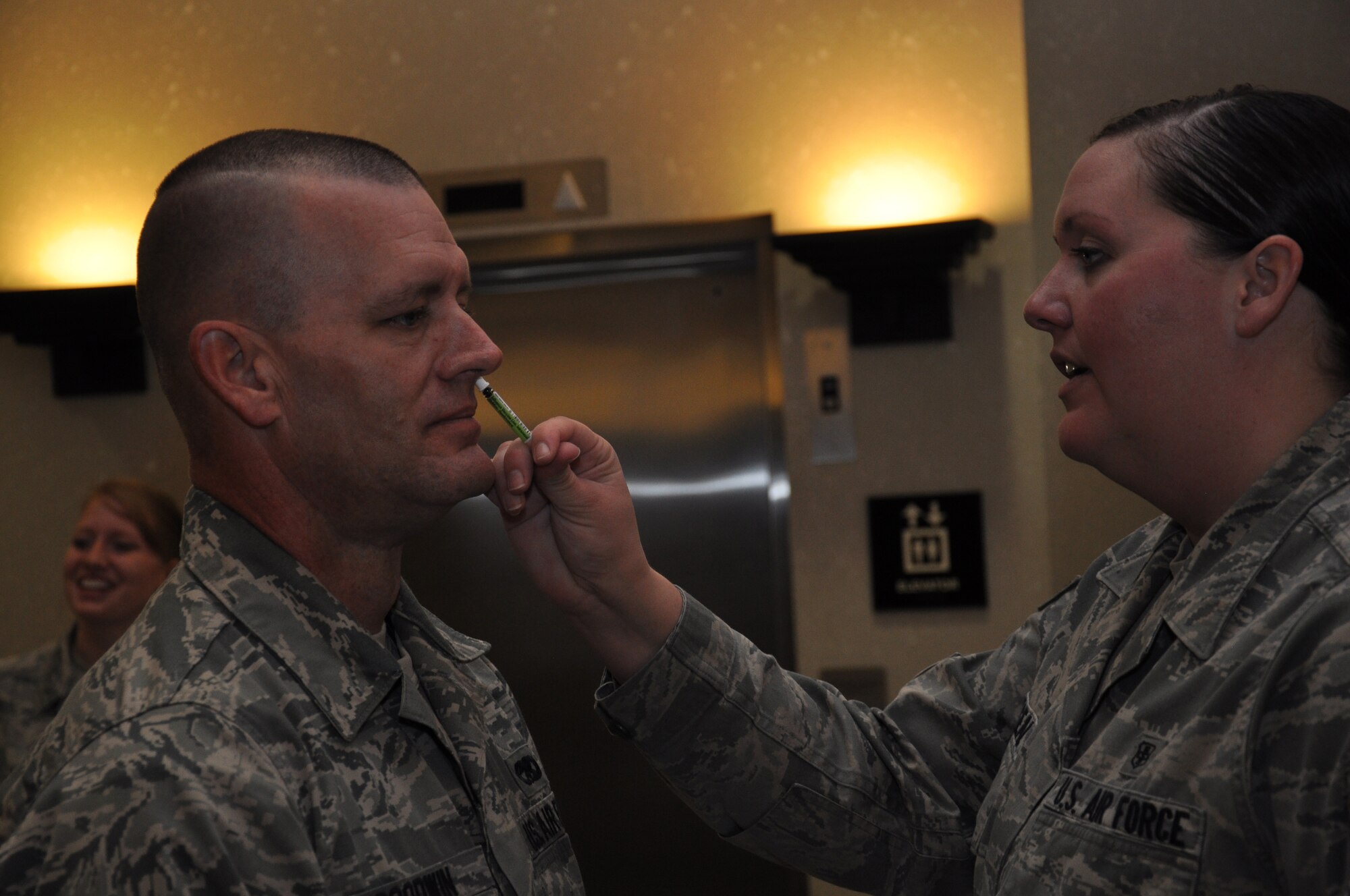 Senior Airman Jamie Godwin, crew chief, 931st Aircraft Maintenance Squadron, receives the flu mist vaccine from Senior Airman Christina Begeal, a medical technician from the 22nd Aerospace Medical Dental Squadron in building 1185 here, Nov. 2. The 22nd AMDS provided immunization support to 931st Air Refueling Group members in the 931st ARG headquarters building to help members accomplish immunization requirements that were delayed by the government shutdown in October. (Air Force photo by Master Sgt. Brannen Parrish)