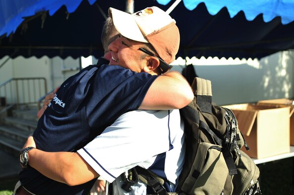 U.S. Air Force Senior Master Sgt. Robert Miller, 909th Aircraft Maintenance Unit superintendant, embraces Tech. Sgt. Makoto Mizuguchi, a Japan Air Self-Defense medical technologist from Naha Hospital during the 14th annual Kadena Special Olympics on Kadena Air Base, Japan, Nov. 2, 2013.  Mizuguchi volunteered his medical ambulance services during the KSO event in the event of a medical emergency. (U.S. Air Force photo by Staff Sgt. Amber E. N. Jacobs)