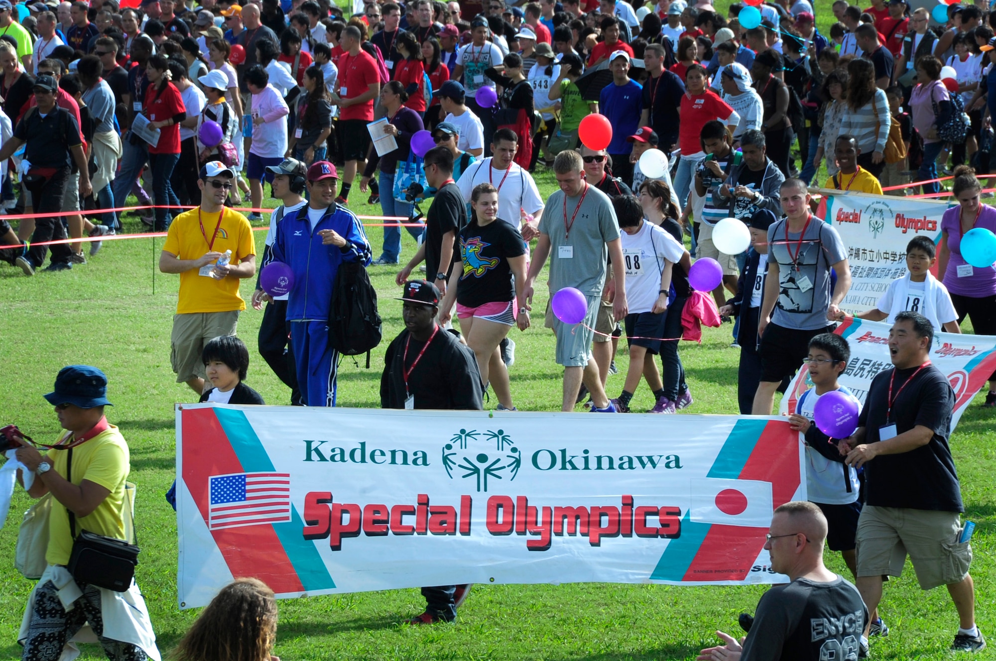 Athletes, volunteers and huggers enter the field during the Kadena Special Olympics, Kadena Air Base, Japan, Nov. 2, 2013. The Kadena Special Olympics is a one-day sporting and entertainment event with more than 840 athletes special olympic athletes and artists participating in a day of competition, music and special recognition. (U.S. Air Force photo by Staff Sgt. Darnell T. Cannady)