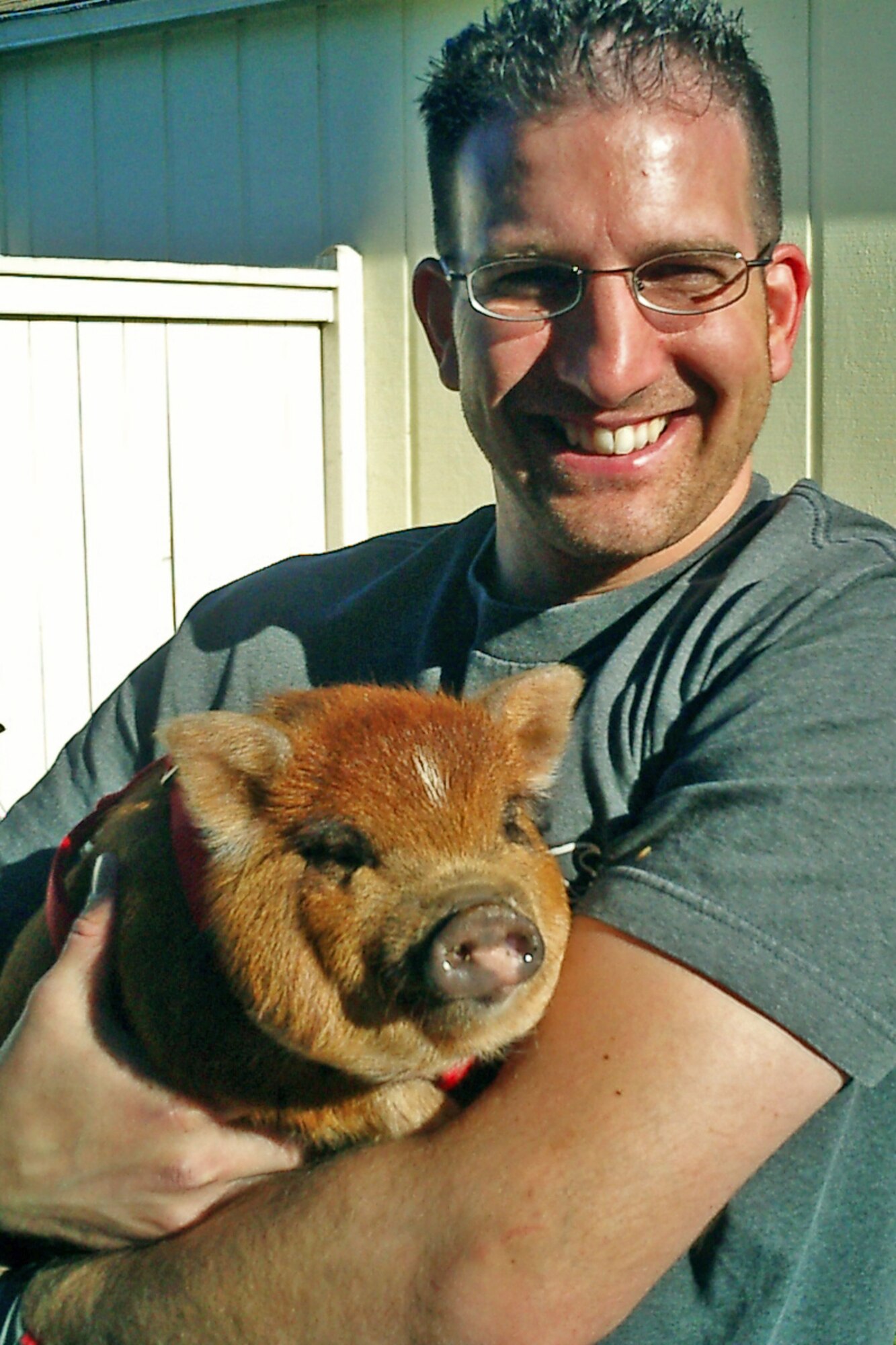 1st Lt. Paul Hall, Medical Readiness Deputy Flight Commander at the 446th Aeromedical Staging Squadron, poses with his pet, Barbie Q, a pot belly pig, at his home in Lacey, Wash. Hall and his wife, Tiffani, own two pot belly pigs, three rats, and several fish. (Courtesy photo)