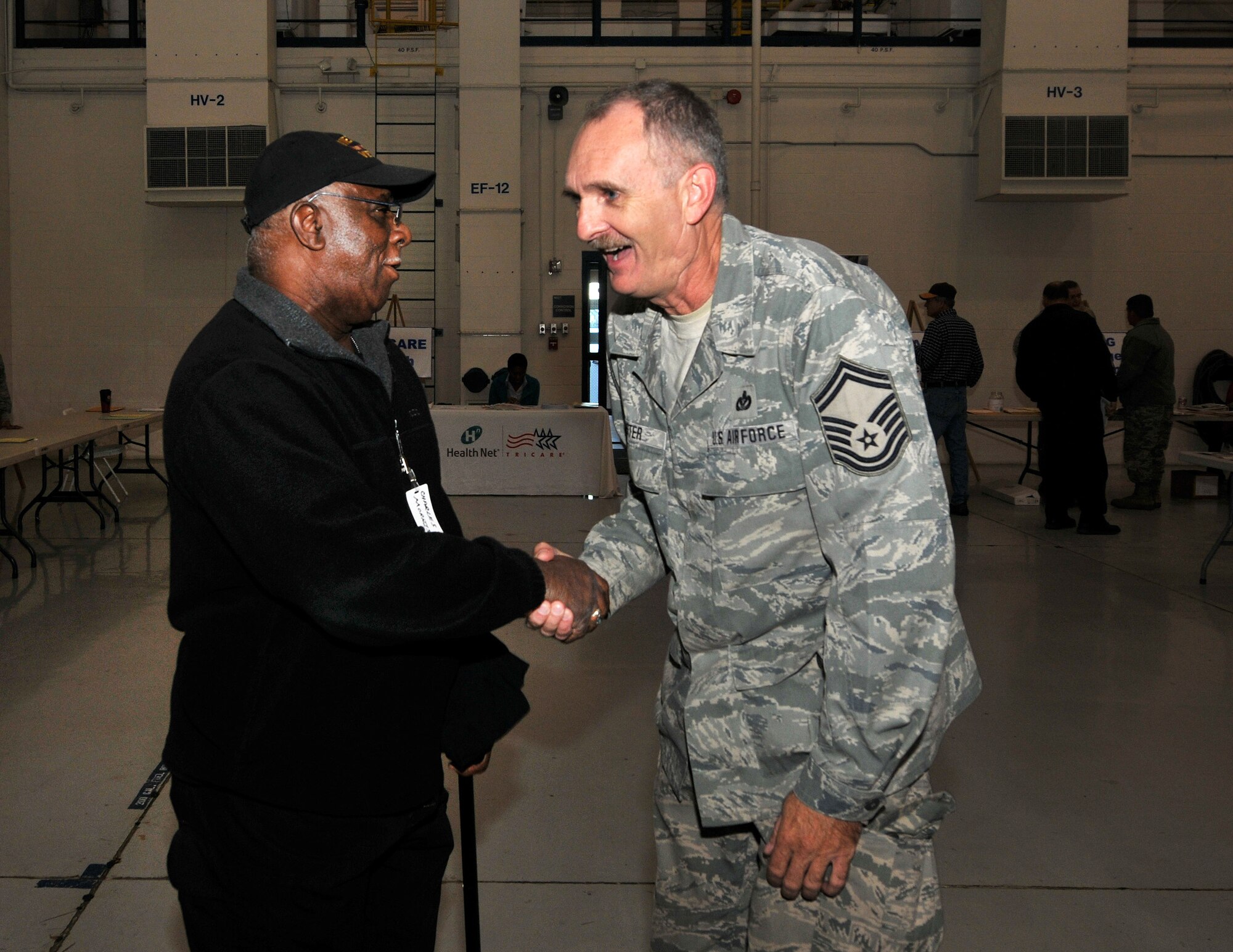 U.S. Air Force Senior Master Sgt. Christopher D. Foster, 145th Civil Engineer Squadron, catches up with retiree Charles Morrison, former member of the 145th Services Flight, North Carolina Air National Guard, at the 18th Annual Retiree Breakfast held in a hanger at the North Carolina Air National Guard base, Charlotte Douglas Intl. Airport, Friday, Oct. 25, 2013. (Air National Guard photo by Master Sgt. Patricia F. Moran/Released) 