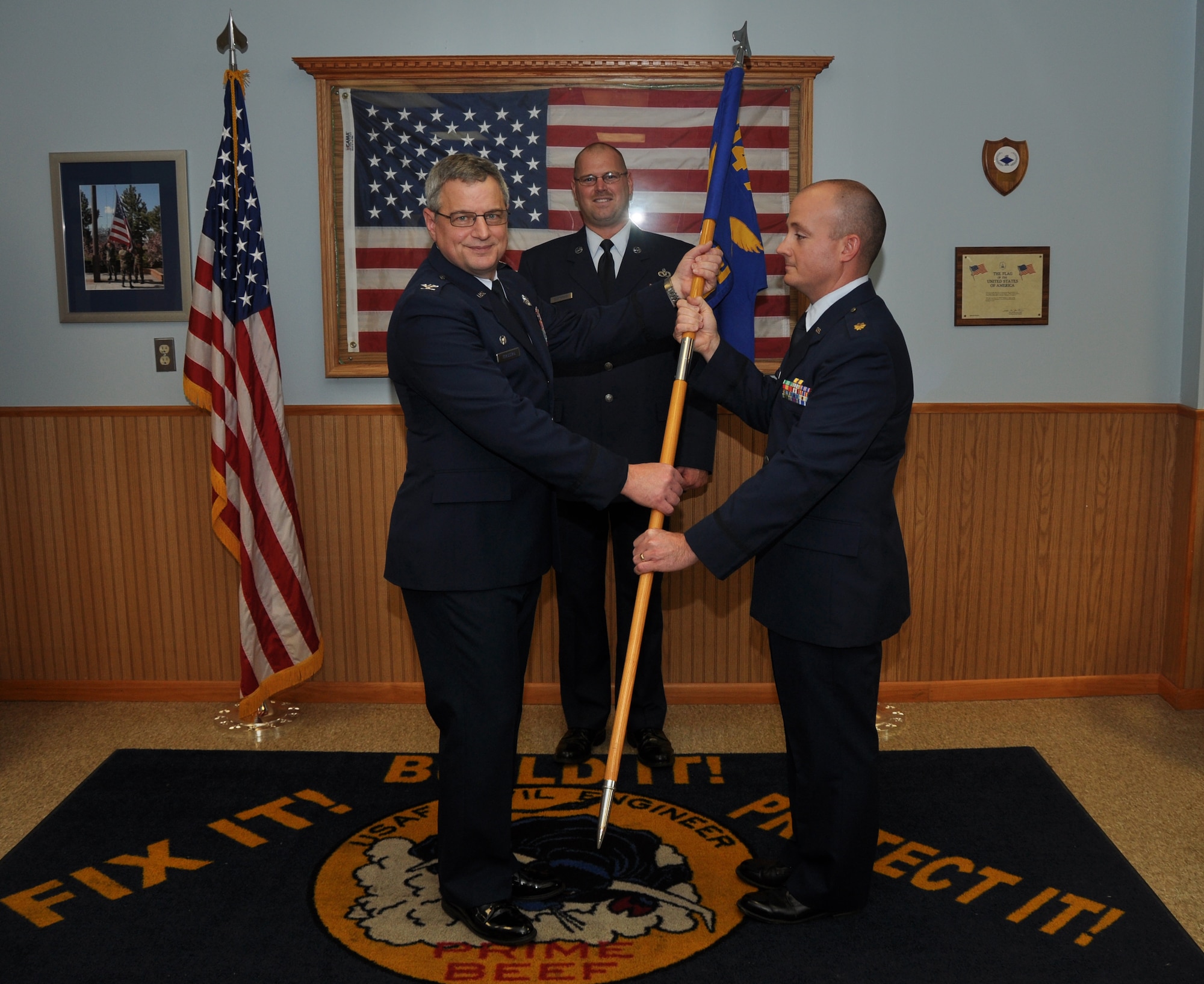 Col. Alan Teauseau, 914th Mission Support Group commander, hands the 914th Civil Engineer Squadron flag over to Maj. Matthew Heinsler as part of a traditional military ceremony symbolizing the assumption of command by Heinsler, November 2, 2013. (U.S. Air Force photo by Staff Sgt. Stephanie Clark) 