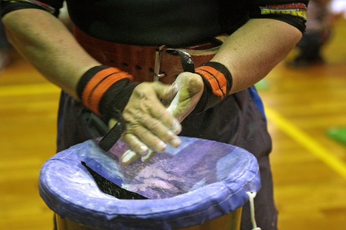 Abe Roman, the overall 2012 open bench press competition winner, coats his hands in chalk in preparation for a lift during the 2012 open bench press competition here Jan. 21. The chalk helps to keep competitors hands dry so the weight does not slip from their hands during the crucial part of a lift.