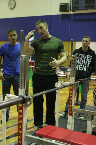 A judge during the 2012 open bench press competition goes over the rules of the competition to volunteers to ensure safety at the IronWorks Gym sports courts here Jan. 21. Many of the competitors also competed in the previous years bench competition as well.