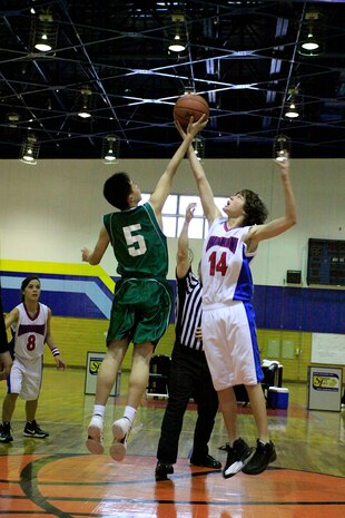 Shinji Hoshide, a Yanai Junior High School student and basketball player, and Michael Coletta, a Matthew C. Perry High School student and team Teddy Bears player, jump for the tip-off in the beginning of the championship game of the basketball tournament held in the IronWorks Gym sports court here Feb. 11.