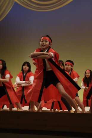 Japanese and American students perform the ‘Sohran Folk Dance’ at Iwakuni Civic Hall during the U.S.-Japan Friendship Concert Feb. 18. The dance takes the rigorous actions of working aboard a fishing boat and turns the movements into a rhythmic and fluid ceremonial dance.