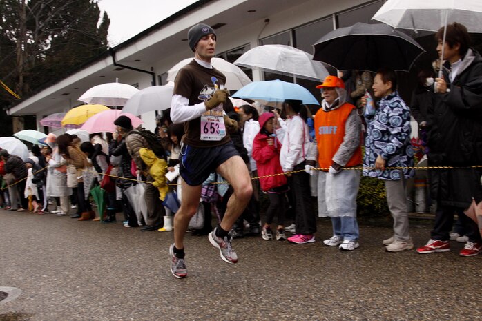 Joseph A. Pacentrilli, a station runner, is cheered on by spectators during the 6th annual Kintai Road Race near the Kintai Bridge SundayMore than 2,200 running enthusiasts, including more than 30 Marines, sailors and station residents, competed in a unique cultural experience between two athletic cultures.