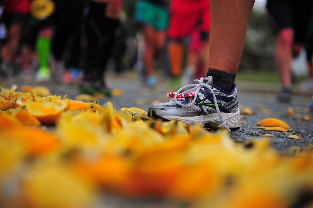 Marathon runners stride through discarded orange slices at the first food station of the Marine Corps Marathon on Oct. 27, 2013.  The runners had just completed the first nine miles of the race. 