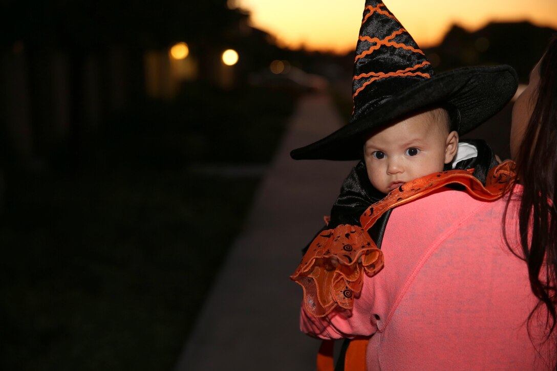 Lillian Haish, a two month old dressed as a witch, looks over her mother's shoulder during trick or treat at base housing aboard Marine Corps Air Station Miramar, Calif., Oct. 31. During trick or treat, children and families dressed up as make-believe monsters in the long-passed tradition of Samhain, an ancient Celtic festival meant to ward off spirits of the dead.