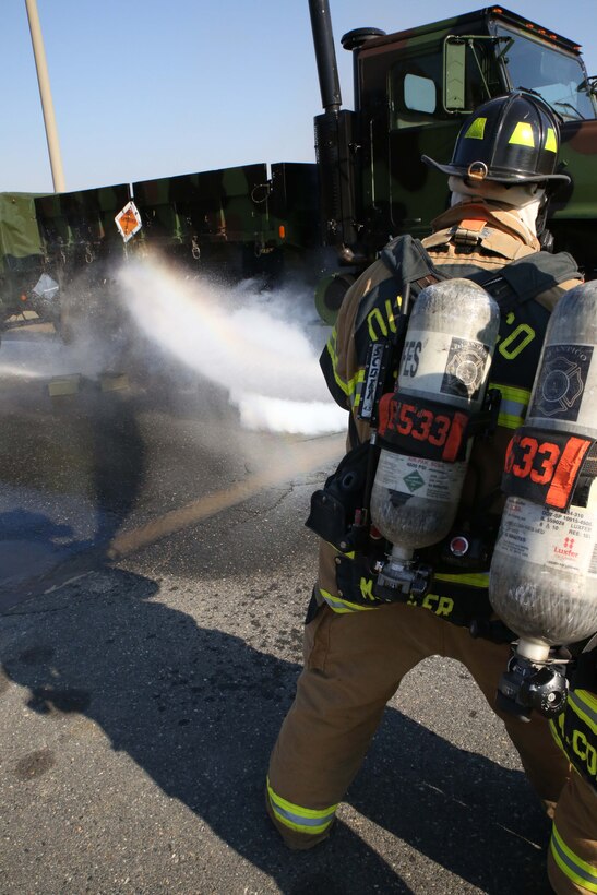 Firefighters Michael Pifer and Marius Cobbs spray a vehicle at the Ammo Supply Point aboard Marine Corps Base Quantico on Oct. 29, 2013. The supply point worked with the Quantico Fire Department to conduct a fire drill.