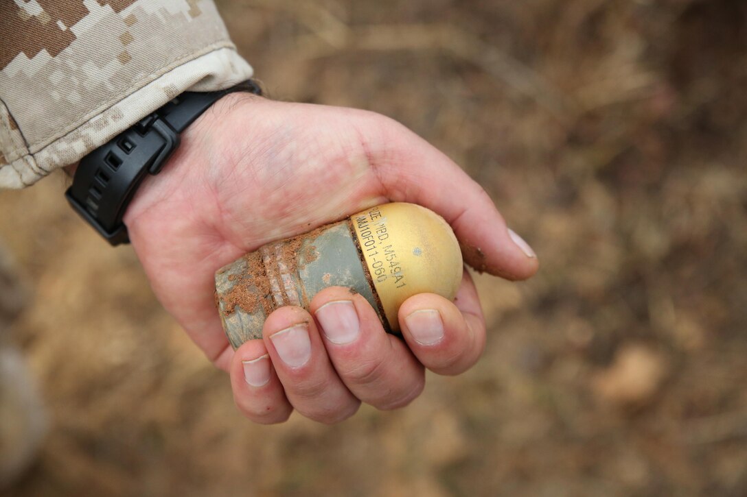 Master Gunnery Sgt. Tanos Chavez holds an unexploded ordnance during a range sweep at Range 7 aboard Marine Corps Base Quantico on Oct. 30, 2013. Marines from the base Explosive Ordnance Disposal unit conduct range sweeps every few months to clear ranges of unexploded ordnances.