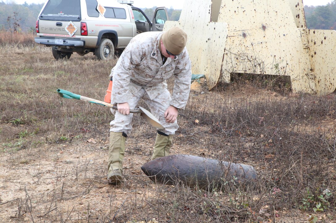 Gunnery Sgt. Gage CoDuto looks at an old shell on Range 7 aboard Marine Corps Base Quantico on Oct. 30, 2013. The Marines, all Explosive Ordnance Disposal technicians, conducted a range sweep to clear the range of unexploded ordnance.