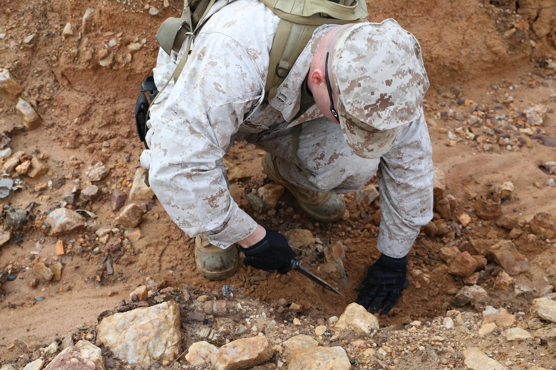 Capt. Jeremiah Hamric uncovers an unexploded ordnance during a range sweep at Range 7 aboard Marine Corps Base Quantico on Oct. 30, 2013. Range sweeps are conducted every few months to clear ranges of unexploded ordnances.