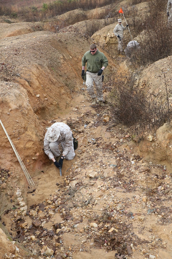 Marines work to uncover unexploded ordnances during a range sweep at Range 7 aboard Marine Corps Base Quantico on Oct. 30, 2013. Marines with the base Explosive Ordnance Disposal unit conduct range sweeps every few months to clear the ranges of any unexploded ordinances.
