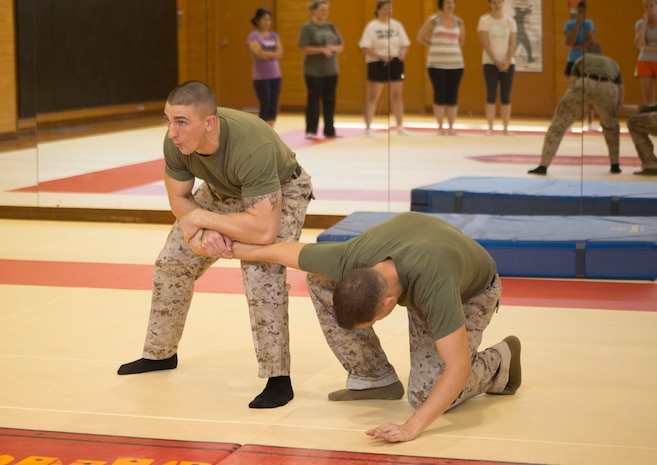 Staff Sgt. Neil Seip, the hazmat staff noncommissioned officer in charge with Marine All-Weather Fighter Attack Squadron 242, demonstrates a wrist manipulation move on Staff Sgt. Thomas Grygowski, maintenance controller with VMFA(AW)-242, during a self-defense class at IronWorks Gym aboard Marine Corps Air Station Iwakuni, Japan, Oct. 10, 2013. Both instructors are black belt instructors for the Marine Corps Martial Arts Program.