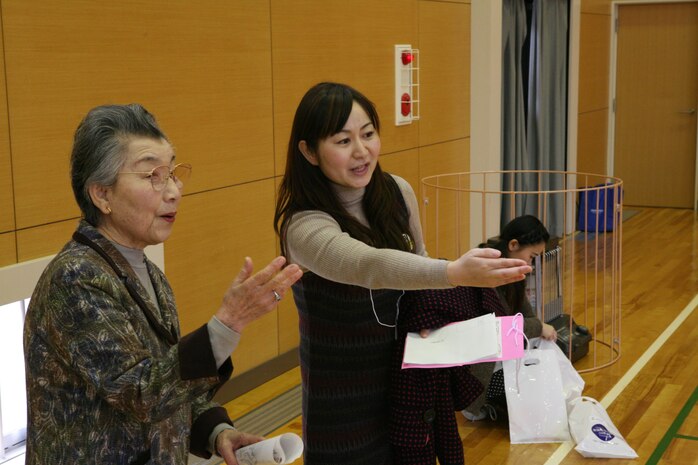 Nami Yamamoto, Marine Corps Community Services youth cultural coordinator, coordinates with Shinjo Kuniko, Iwakuni Junior College principal, during the Iwatan Oyako Festa Jan. 28. The Festa was one of many cultural exchange events Yamamoto offers station residents.