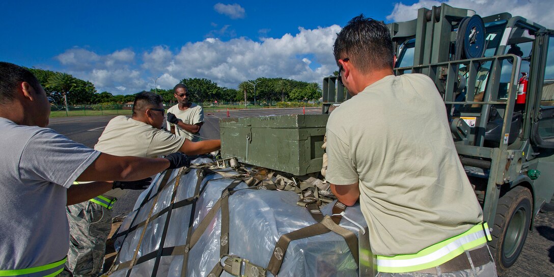 Members from the 624th Civil Engineer Squadron remove an equipment container from a pallet prior to processing and positioning their equipment at the chalk line near the flightline during an Operational Readiness Inspection at Joint Base Pearl Harbor-Hickam, Hawaii, Nov. 3, 2013. The inspection evaluated their ability to properly react to a broad range of scenarios and environmental conditions. (U.S. Air Force photo/Tech. Sgt. Jerome Tayborn)