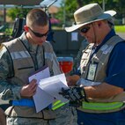 Airman 1st Class Joshua Mattlach, 15th Aircraft Maintenance Squadron guidance and control, left, gets his shipping documentation checked for accuracy by Micheal Kuklok, Naval Facilities Base Services Vehicle Equipment, cargo in-check lead, right, near the flightline during an Operational Readiness Inspection at Joint Base Pearl Harbor-Hickam, Hawaii, Nov. 3, 2013 The Consolidated Unit Inspection is designed to evaluated 15th Wing and 154th Wing capabilities to respond to real world contingencies.  (U.S. Air Force photo/Tech. Sgt. Jerome Tayborn)
