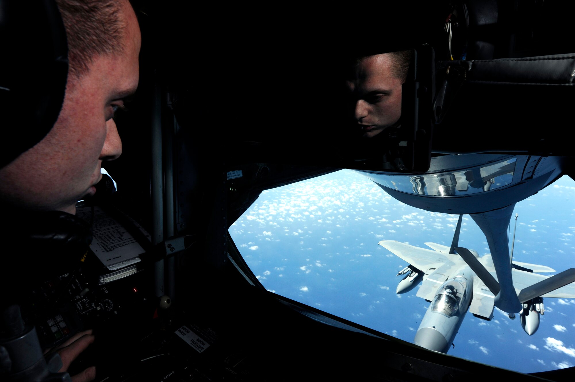 U.S. Air Force Airman 1st Class Andrew Cole, 909th Air Refueling Squadron boom operator, guides a refueling boom from a KC-135 Stratotanker aerial refueling aircraft to an F-15 Eagle from the 67th Fighter Squadron over the Pacific Ocean Oct. 28, 2013. During the mission, six 67th FS F-15s returned to Kadena after a three-week deployment to Singapore. (U.S. Air Force photo by Senior Airman Maeson L. Elleman)