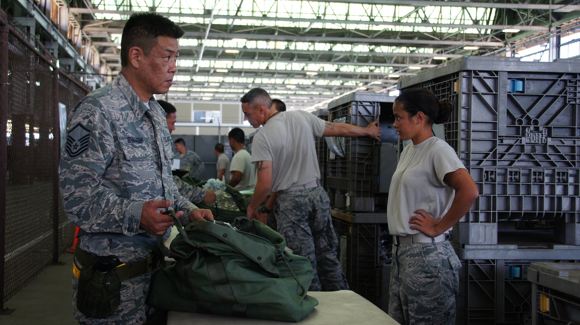 Tech. Sgt. Tracy Ohgashi receives an equipment bag for an exercise deployment during Combined Unit Inspection (CUI), Nov. 03, at Joint Base Pearl Harbor-Hickam. The CUI is the final step in over 18 months of preparation and exercises by the active duty’s 15th Wing and the Hawaii Air National Guard’s 154th Wing. The inspection allows the wings to prove their ability to deploy quickly in response to an international threat, and their operational readiness in a foreign combat scenario. (Air National Guard photo/TSgt Andrew Jackson/Released)