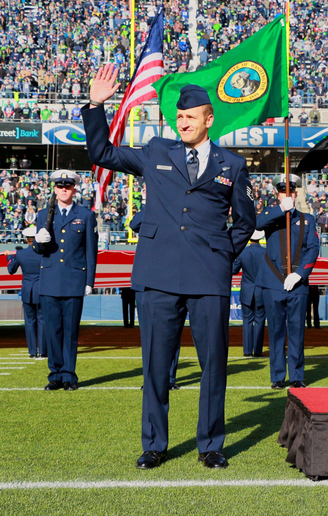 Staff Sgt. Kyle Knox, 446th Aeromedical Evacuation Squadron medical technician, waves to Seattle Seahawks fans while his name is announced at the Nov. 3 Seahawks game at Century Link Field in Seattle. Knox has been in the Air Force Reserve for six years and signed up for another two years by reenlisting on the field before the game. (U.S. Air Force Reserve photo by Senior Airman Madelyn McCullough)