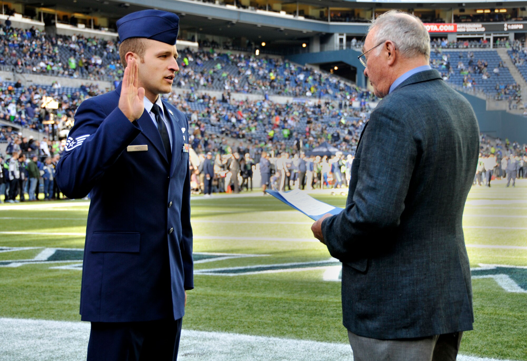 Staff Sgt. Kyle Knox (left), 446th Aeromedical Evacuation Squadron air reserve technician, repeats the oath of enlistment after his grandfather, retired Lt. Col. James Rankin, before the Seattle Seahawksgame at Century Link Field in Seattle Nov. 3. Knox is committing another two years to the Air Force Reserve. (U.S. Air Force Reserve photo by Senior Airman Madelyn McCullough)