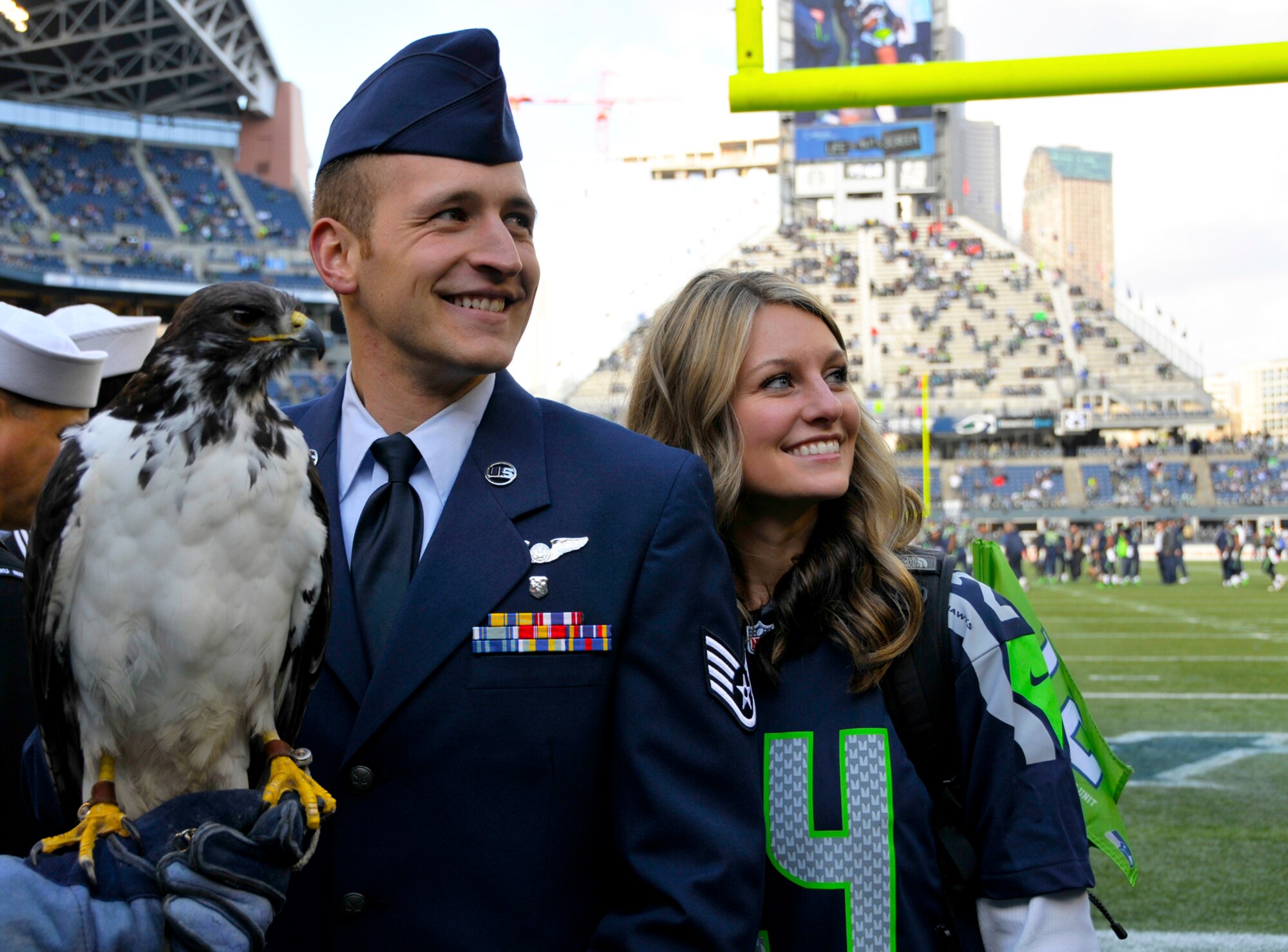 Staff Sgt. Kyle Knox (left), 446th Aeromedical Evacuation Squadron air reserve technician, and his wife, Courtney Knox, smile for a photo with a Hawk at Century Link Field in Seattle Nov. 3. Knox was given the honor of reenlisting on the field before the Seattle Seahawks  game because the 446th Airlift Wing has been adopted as the Seahawks' military unit for the 2013 season. (U.S. Air Force Reserve photo by Senior Airman Madelyn McCullough)