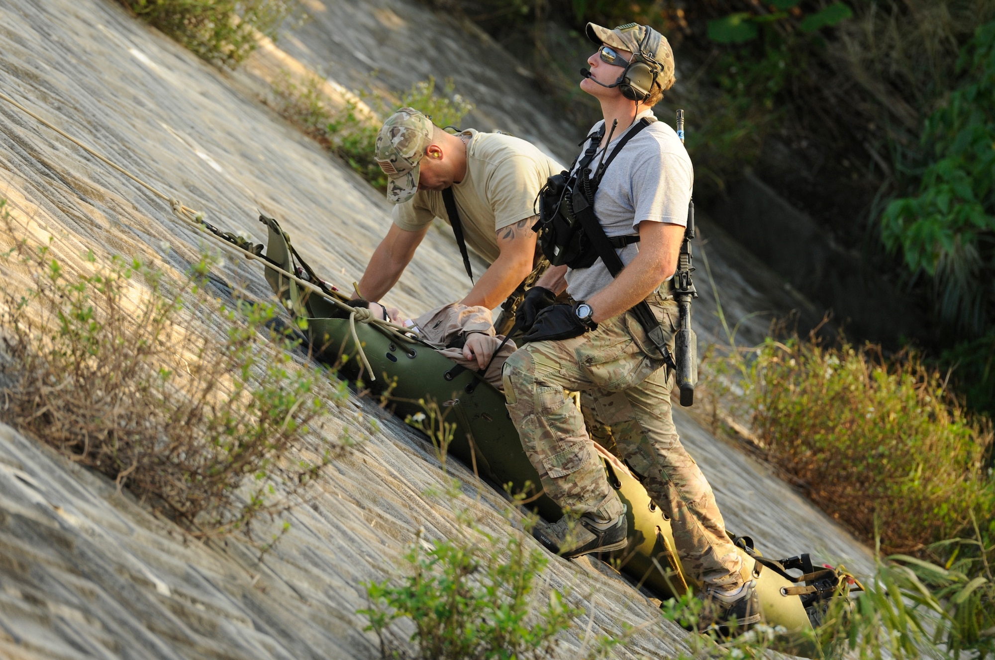 U.S. Air Force Tech. Sgt. Antonio Rivera, 31st Rescue Squadron resource advisor, and Senior Airman David Jones, 31st RQS survival evasion resistance and escape specialist, haul a simulated casualty during a war week exercise at Marine Corps Camp Hansen's training area, Japan, Oct. 29, 2013. The exercise gave members from both of Kadena Air Base's rescue squadrons the opportunity to practice numerous rescue scenarios in a controlled environment. (U.S. Air Force photo by Senior Airman Marcus Morris)   