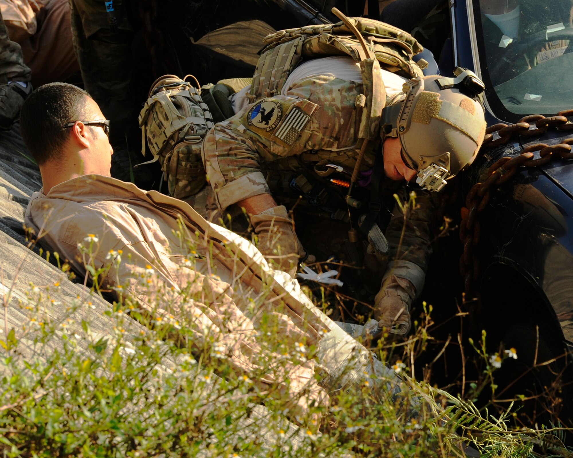 U.S. Air Force Senior Airman Patrick Moore, 48th Rescue Squadron pararescueman from Davis-Monthan Air Force Base, Arizona, cuts open the pants of Senior Airman Michael Irizarry, 718th Aircraft Maintenance Squadron crew chief, to assess his injuries during a war week exercise at Marine Corps Camp Hansen's training area, Japan, Oct. 29, 2013. The multidimensional exercise allowed the pararescuemen to train for worst case scenarios to prepare for real-life situations they could experience while deployed. (U.S. Air Force photo by Senior Airman Marcus Morris)