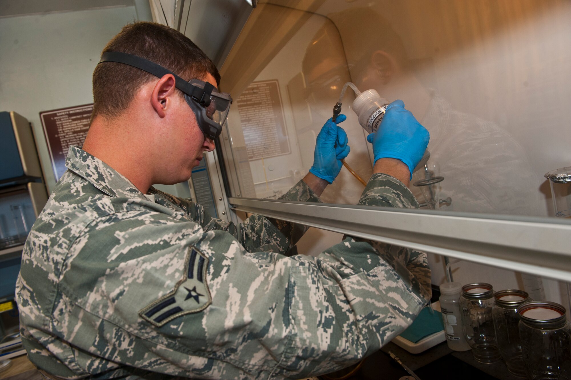 Airman 1st Class Nickolauss Guier, 99th Logistics Readiness Squadron fuel lab technician, uses petroleum ether to sanitize fuel lab equipment in the fuels management building Nov. 1, 2013, at Nellis Air Force Base, Nev. Petroleum ether is a non-toxic cleaning compound used to clean residual fuel off equipment. (U.S. Air Force photo/Senior Airman Brett Clashman)