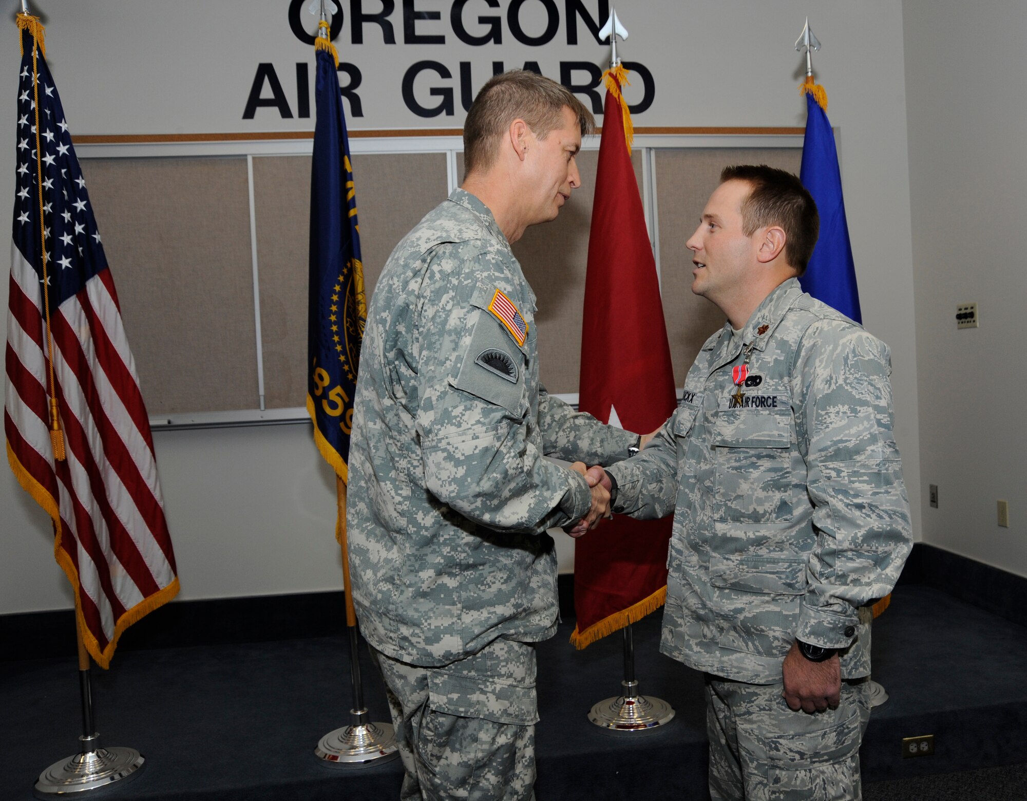 Maj. Gen. Daniel Hokanson, Adjutant General Oregon, congratulates Maj. Casey Dierickx, 142nd Fighter Wing executive officer, during a Bronze Star ceremony held at the Portland Air National Guard Base, Ore., on Nov. 3, 2013. As part of the ceremony, both Dierickx and Senior Master Sgt. Brian Wade, of the 142nd Fighter Wing Explosive Ordinance Disposal unit, were awarded the Bronze Star for their service during Operation Enduring Freedom. (Air National Guard photo by Tech. Sgt. John Hughel, 142nd Fighter Wing Public Affairs/released)