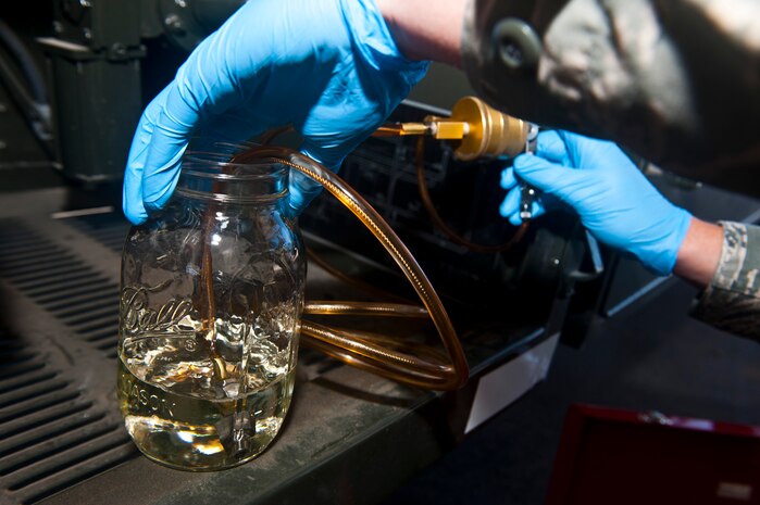 Airman 1st Class Nickolauss Guier, 99th Logistics Readiness Squadron fuel lab technician, collects fuel from an R-11 fuel truck in the fuels management building Nov. 1, 2013, at Nellis Air Force Base, Nev. Guier was collecting a fuel sample to test later to test the water and fine sediment inside the fuel lab. (U.S. Air Force photo/Senior Airman Brett Clashman)
