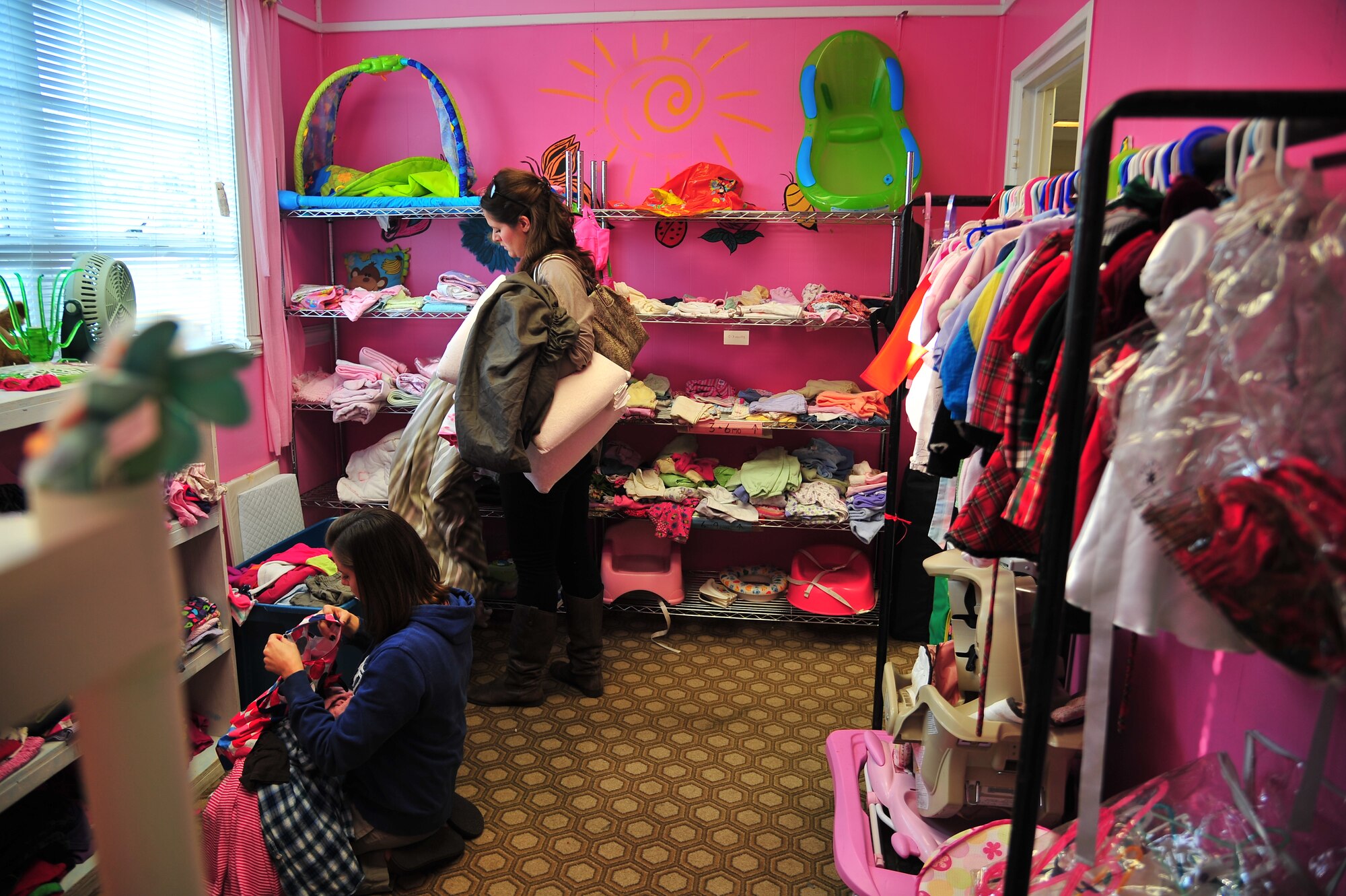 Traci Dobson, left, and Megan Owens shop for children’s clothing in the Airman’s Attic at Seymour Johnson Air Force Base, N.C., Oct. 31, 2013. The at-no-cost shopping center is open to Airmen, E-1 through E-6, and their dependents on Wednesdays from 9 a.m. to 12 p.m. Dobson is the spouse of Staff Sgt. Russell Dobson, 4th Equipment Maintenance Squadron maintainer, and Owens is the spouse of Senior Airman Adam Owens, 4th Aircraft Maintenance Squadron crew chief. (U.S. Air Force photo by Senior Airman Aubrey White)