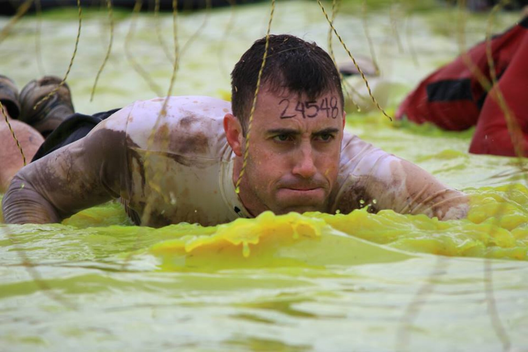 U.S. Army Capt. Michael McCrory, Initial Military Training Center of Excellence aide-de-camp for the deputy commanding general, swims through the “Electric Eel” obstacle during the Tough Mudder event at the Peacemaker National Training Center in Gerrardstown, W.Va., Oct. 20, 2013. McCrory was a part of a Joint Base Langley-Eustis team who completed 12 miles of obstacles in three-and-a-half hours. (Courtesy photo/Released)