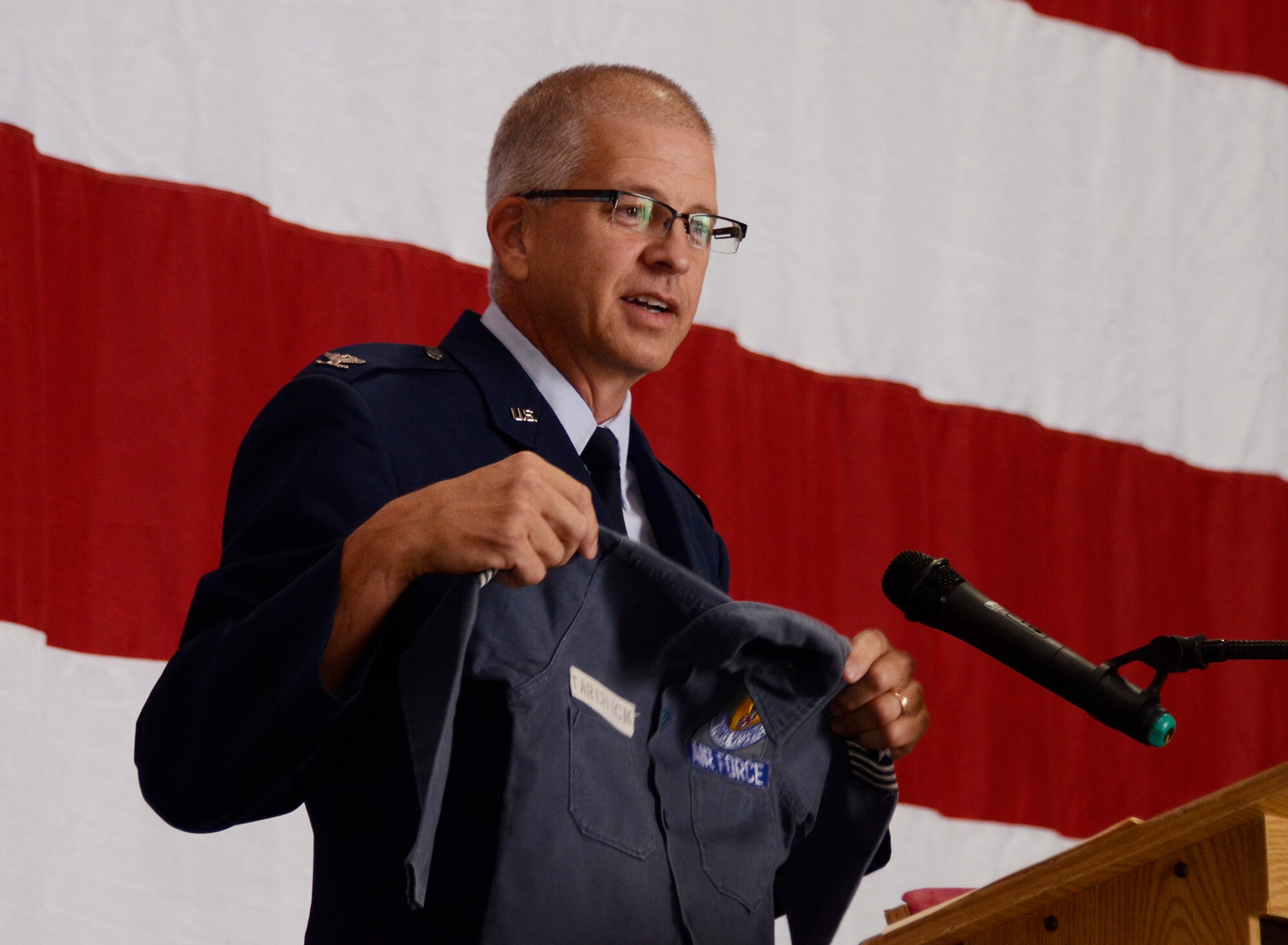 Col. Tim Tarchick, 94th Airlift Wing commander displays a shirt he wore as a child expressing his desire to join the Air Force at a young age during his retirement ceremony Oct. 31 at Dobbins Air Reserve Base, Ga. (U.S. Air Force photo/Don Peek)