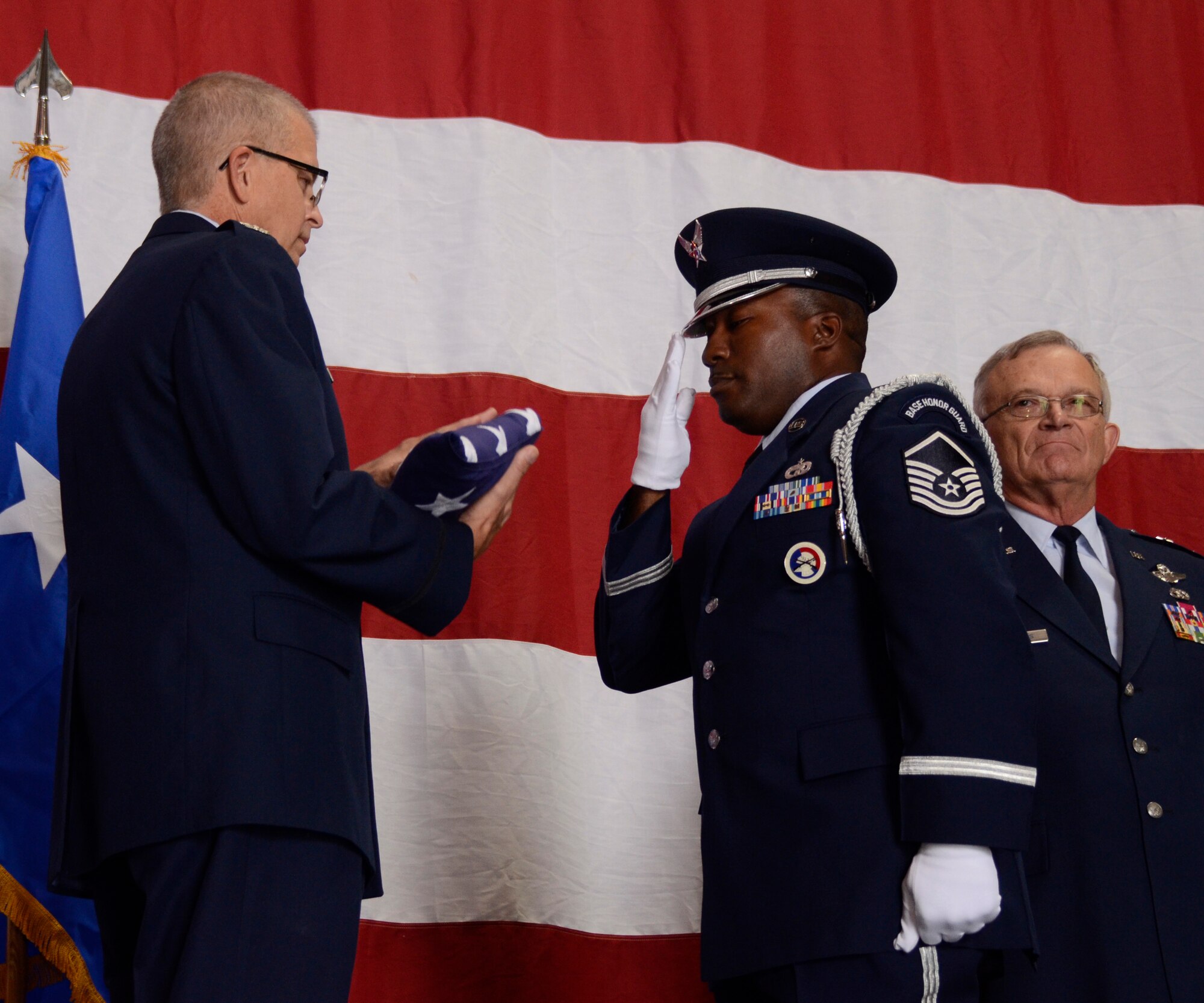 Master Sgt. Aaron J. Albright, 94th Airlift Wing Honor Guard, superintendent, presents Col. Tim E. Tarchick, 94th AW commander with the ceremonial U.S. flag during his retirement ceremony Oct. 31 at Dobbins Air Reserve Base, Ga. Maj. Gen. (Ret) James D. Bankers, former 22nd Air Force commander, looks on. (U.S. Air Force photo/Don Peek)