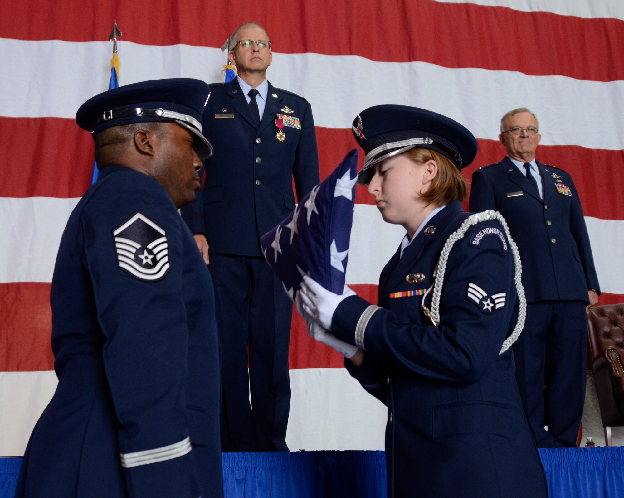 Master Sgt. Aaron Albright, superintendent, and Senior Airman Kellie Creel of the 94th Airlift Wing Honor Guard perform the traditional flag folding ceremony in honor of Col. Tim E. Tarchick, wing commander, during his retirement ceremony Oct. 31 at Dobbins Air Reserve Base, Ga. Maj. Gen. (Ret) James D. Bankers, former 22nd Air Force commander, looks on. (U.S. Air Force photo/Don Peek)