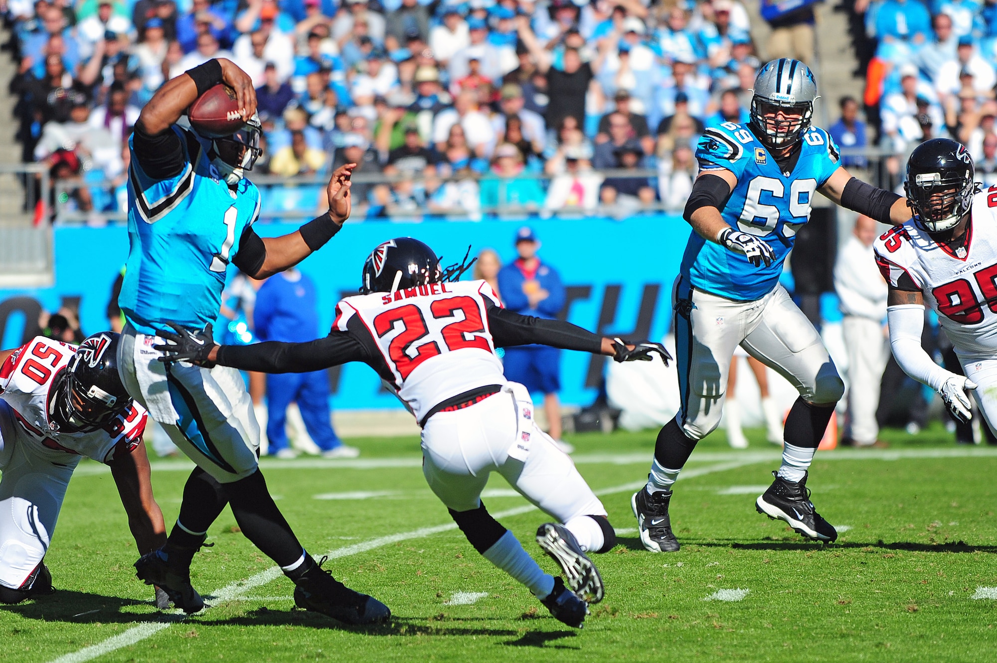 Cam Newton, Carolina Panthers quarterback, maneuvers around Asante Samuel, Atlanta Falcons cornerback, during a game at Bank of America Stadium in Charlotte, N.C., Nov. 3, 2013. Prior to the start of the game, five members of Team Seymour were recognized for their service. (U.S. Air Force photo by Airman 1st Class John Nieves Camacho)