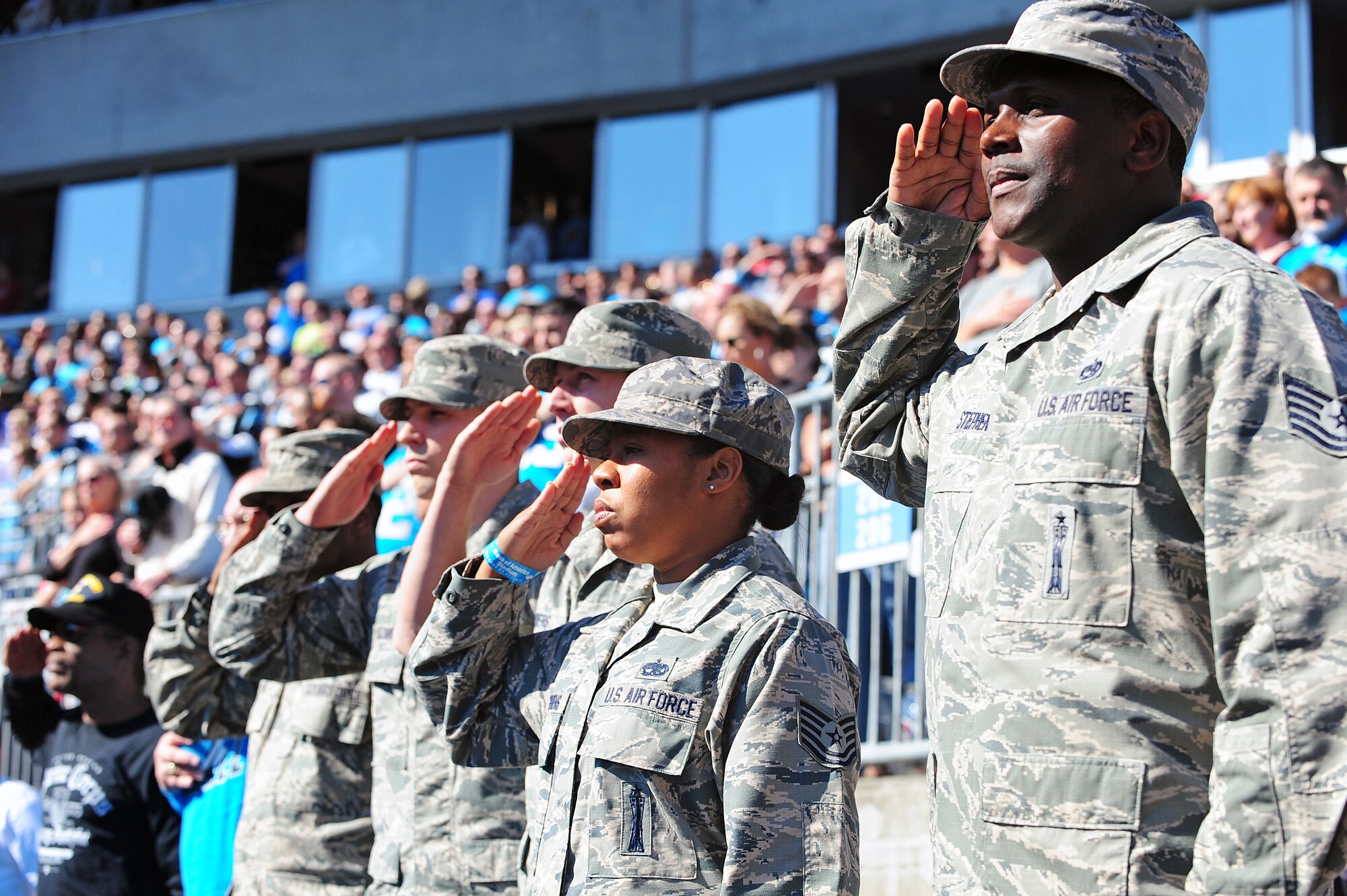 Service members in the “Row of Honor” render salutes during the National Anthem at Bank of America Stadium in Charlotte, N.C., Nov. 3, 2013. Five Airmen from Seymour Johnson Air Force Base were selected by the USO of North Carolina Panthers as special guests for their selfless service to their country. (U.S. Air Force photo by Airman 1st Class John Nieves Camacho)