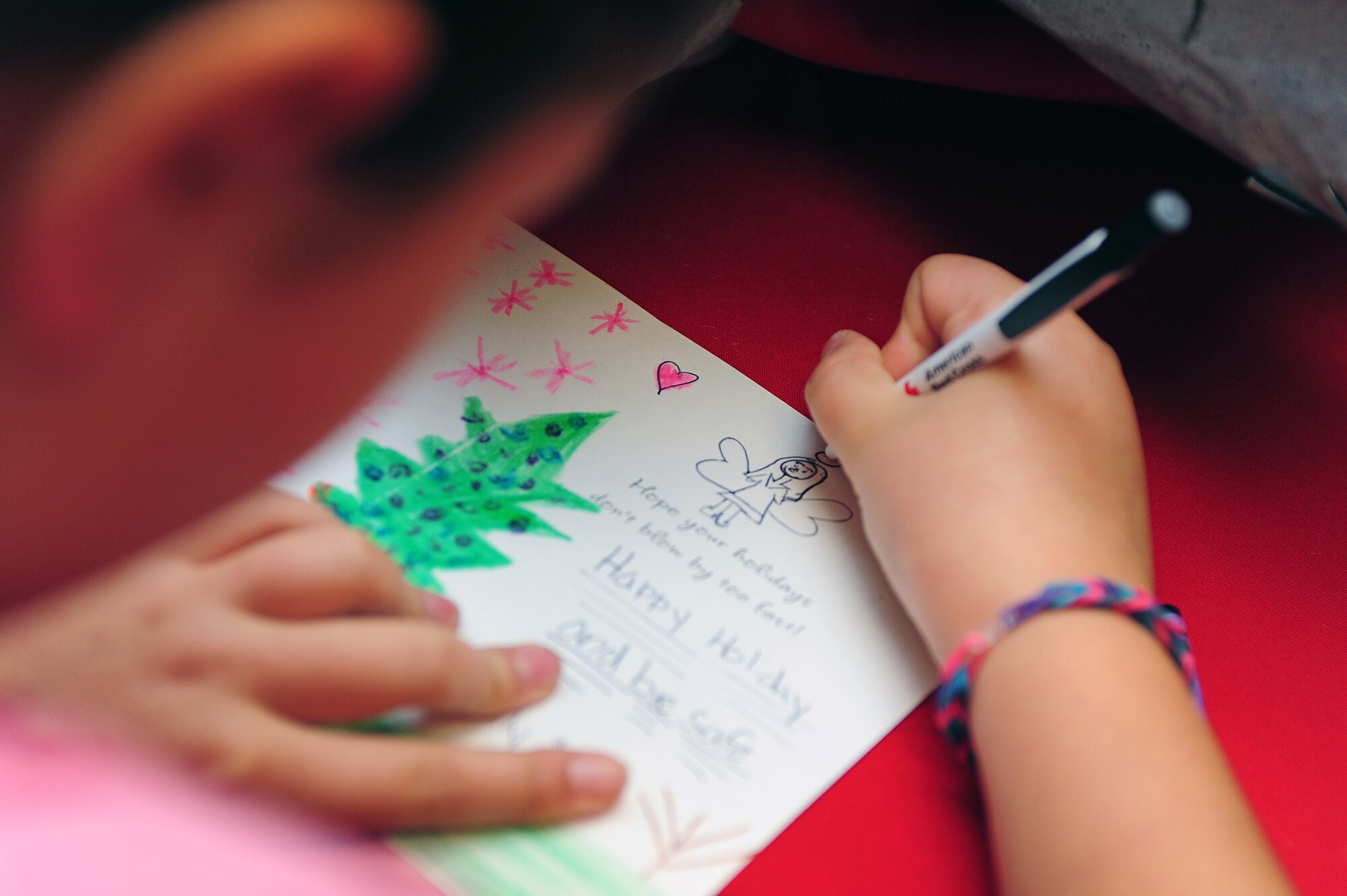 A child draws an angel on a card during the American Red Cross Holiday Mail for Heroes event at Seymour Johnson Air Force Base, N.C., Nov. 1, 2013. Members of Team Seymour and the American Red Cross gathered to fill the cards with season’s greetings for deployed Service members. (U.S. Air Force photo by Airman 1st Class John Nieves Camacho)