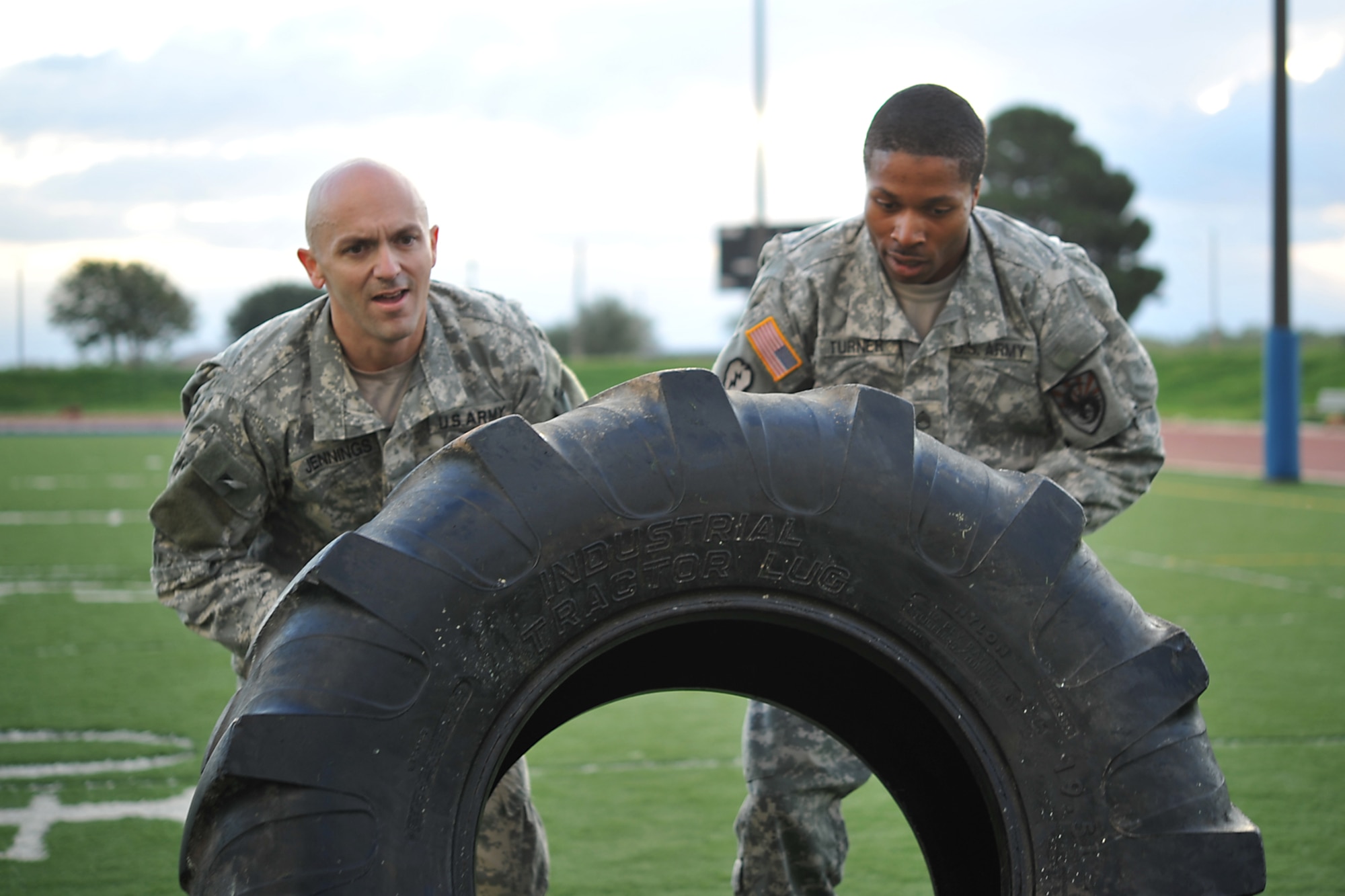 GOODFELLOW AIR FORCE BASE, Texas-- Army 1st Sgt. Ian Jennings, 344th Military Intelligence Battalion First Sergeant, and Staff Sgt. Deontra Turner, 344th MIBN Platoon Sgt., flip a tire during the Iron Soldier Competition Oct. 26. The competition is made up of teams of four soldiers who race against time to complete grueling physical and mental task. (U.S. Air Force photo/ Senior Airman Michael Smith)